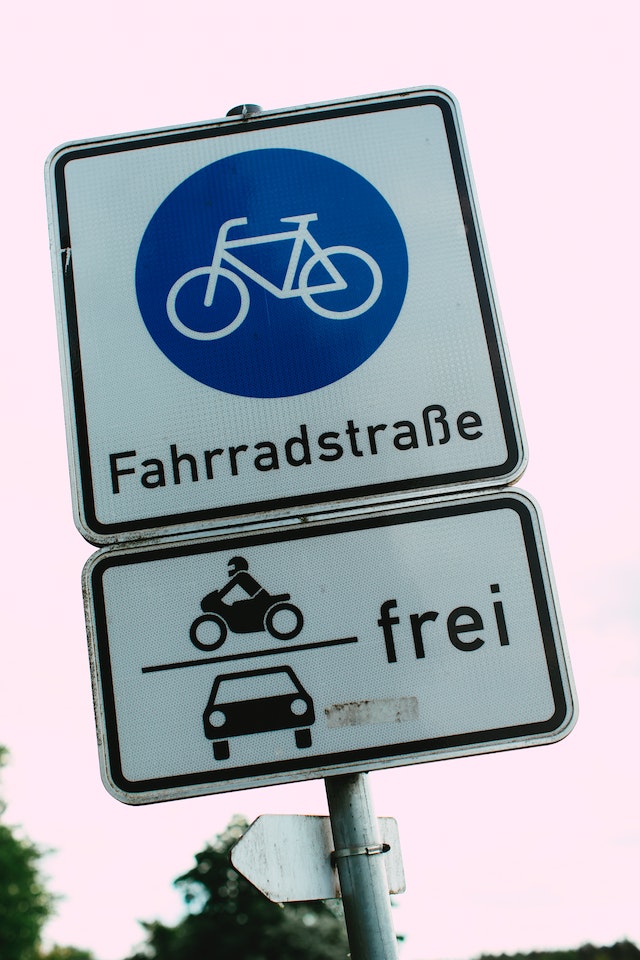 Das Verkehrsschild für die Fahrradstraße ist weiß und quadratisch. Es zeigt ein weißes Fahrrad in einem blauen Kreis, darunter ist der Schriftzug „Fahrradstraße“ abgebildet